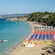 Lounge chairs, umbrellas and boats line a stretch of shoreline on Makris Beach